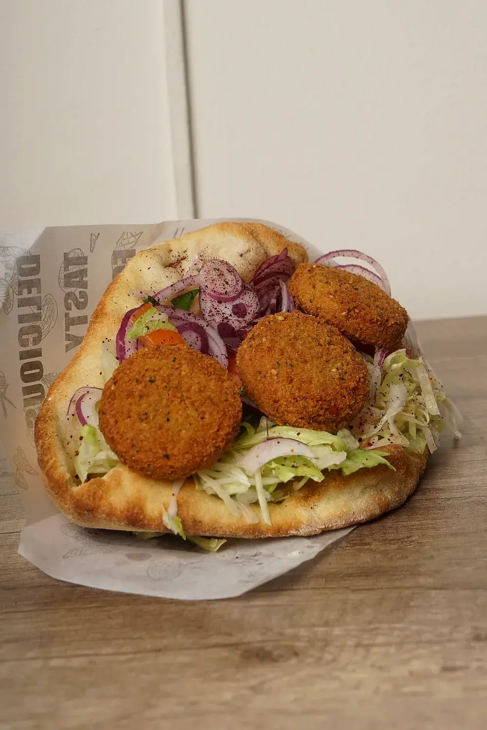 Falafel im Fladenbrot mit Salat und roten Zwiebeln