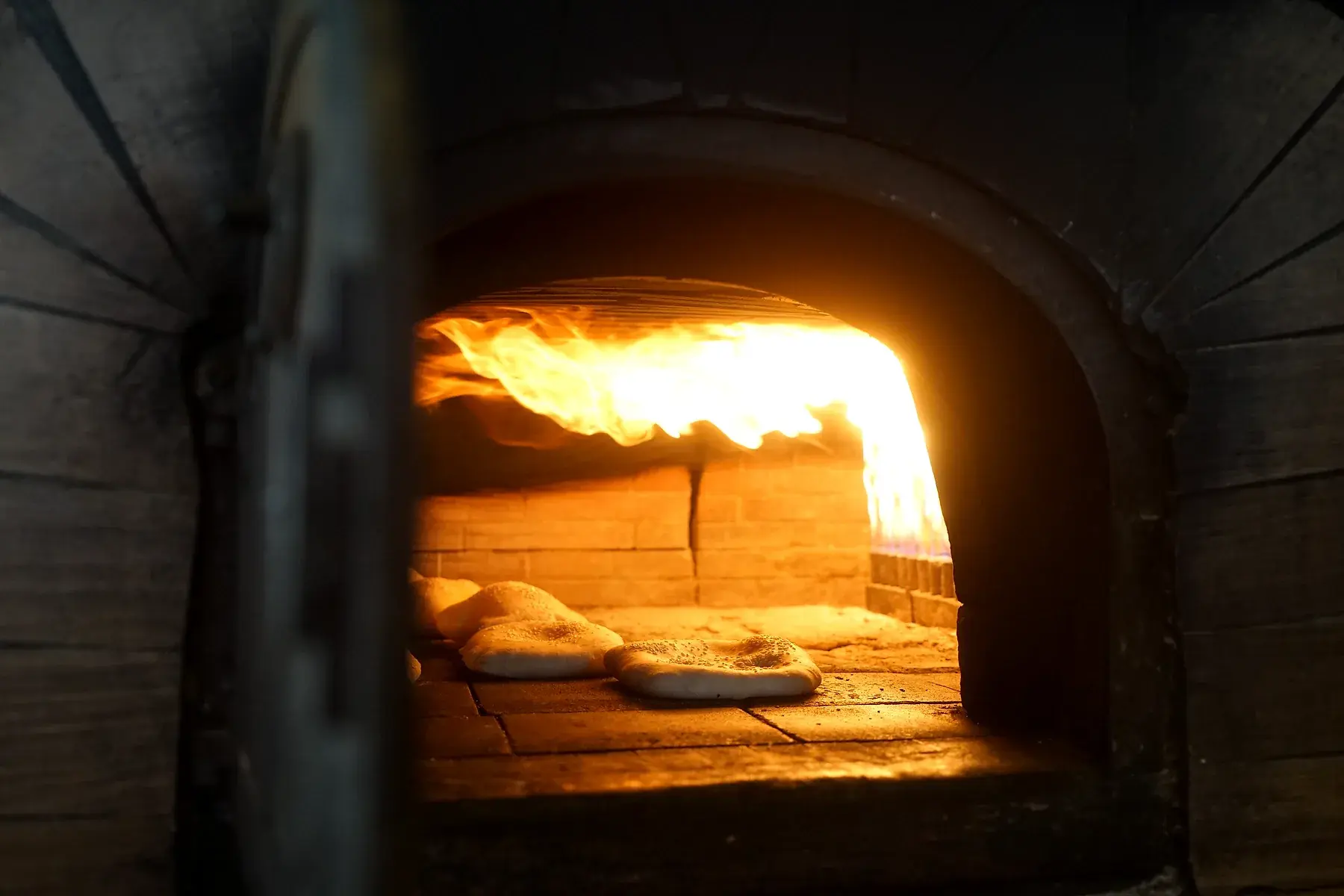 Flamme im Steinofen über dem Fladenbrot