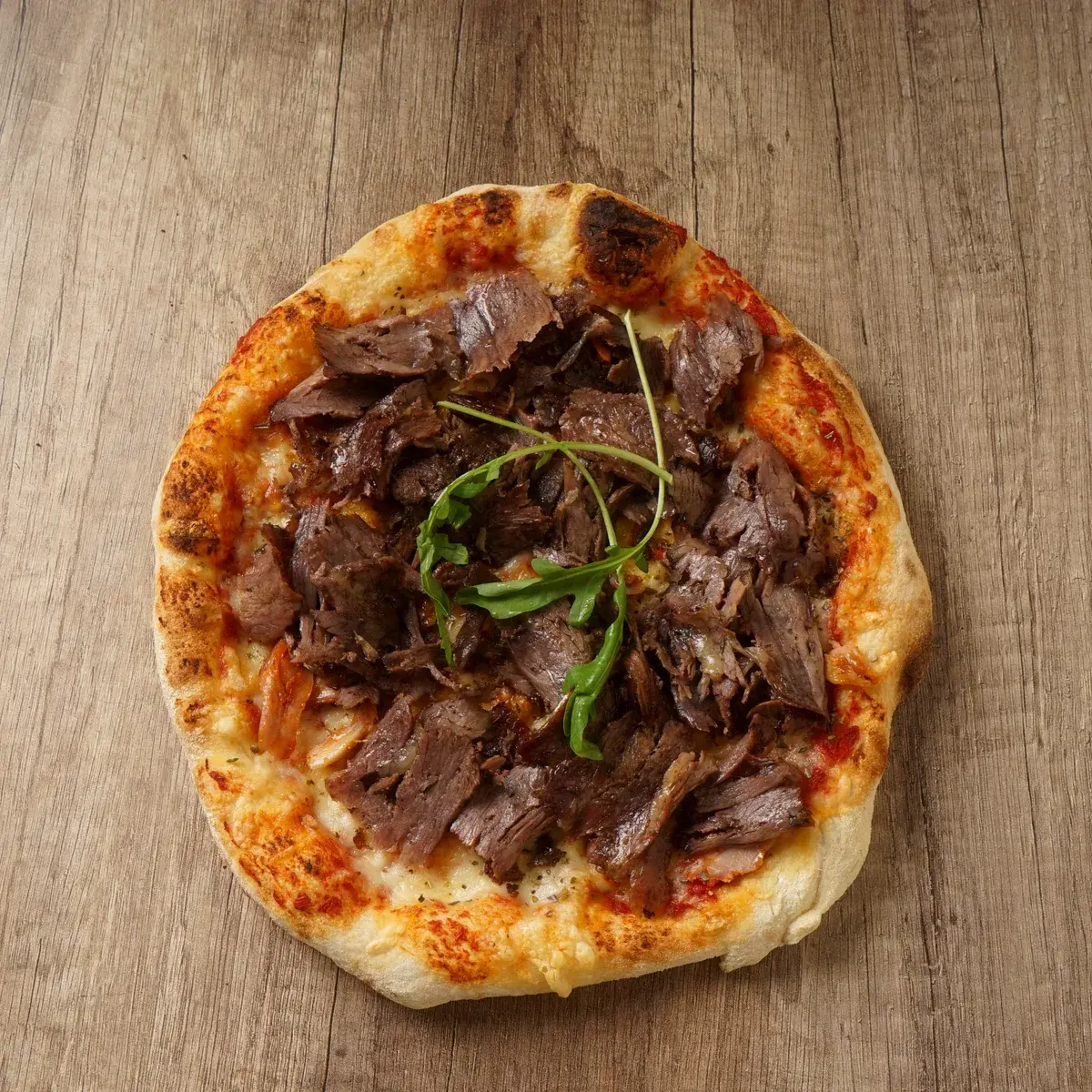Steinofen Pizza Steak von oben auf dem Holztisch