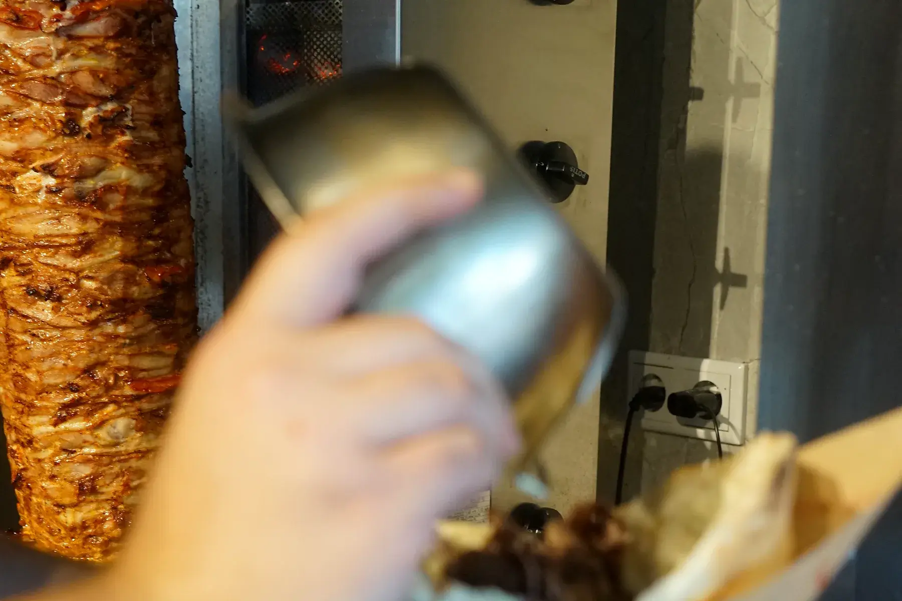 Sauce wird über den frisch belegten Döner gegeben
